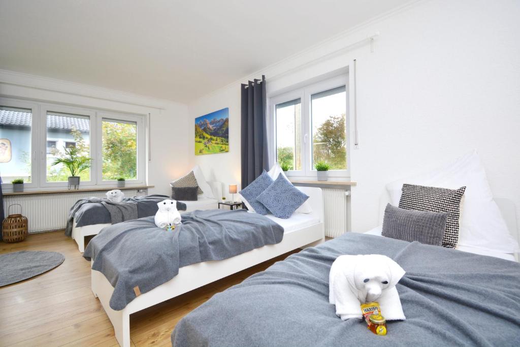 ein Schlafzimmer mit drei Betten mit einem weißen Hund drauf in der Unterkunft BA02-RI Apartment bei Bamberg in Reckendorf