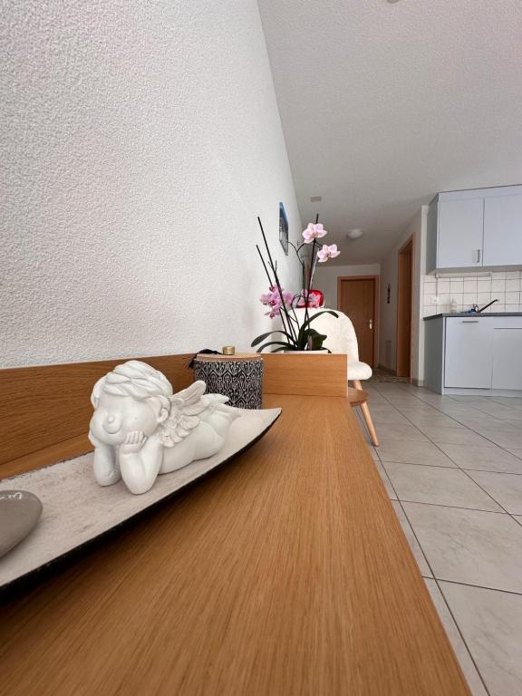 una sala de estar con una mesa con una estatua. en Haus Mondelli, en Saas-Almagell