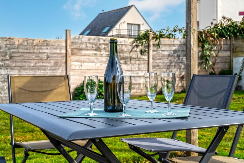 a table with wine glasses and a bottle on it at Meublé De Tourisme Acanthe in Camaret-sur-Mer