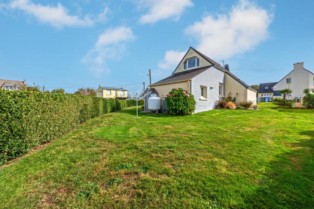 a house in a yard with a green lawn at Meublé De Tourisme Acanthe in Camaret-sur-Mer