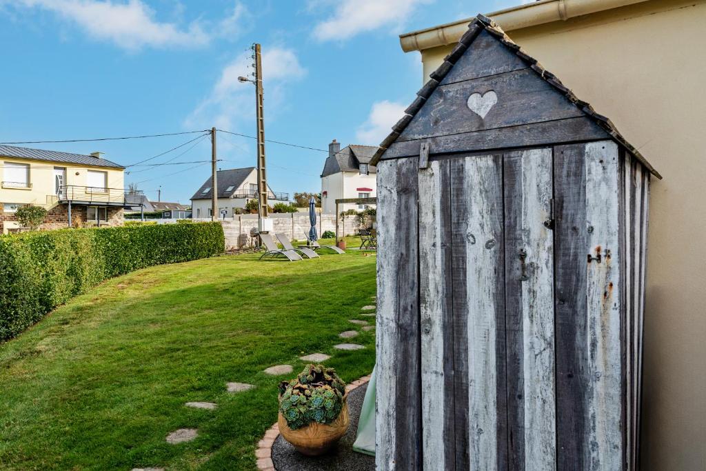 a small wooden shed sitting next to a yard at Meublé De Tourisme Acanthe in Camaret-sur-Mer