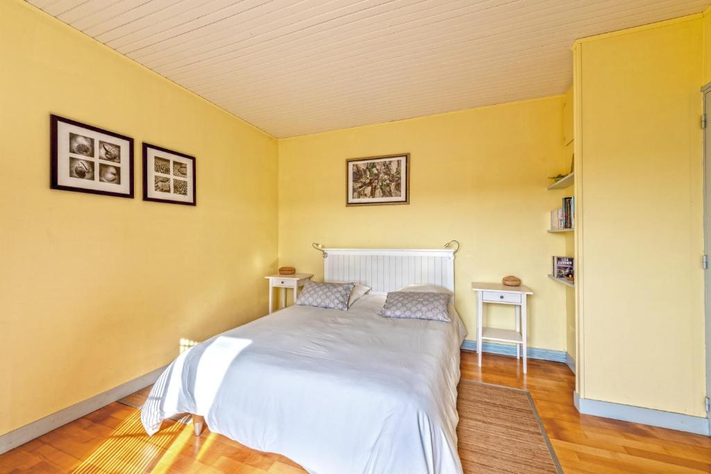 a bedroom with a white bed and yellow walls at Meublé De Tourisme Acanthe in Camaret-sur-Mer