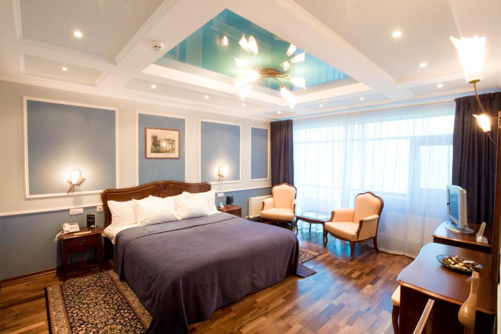 a hotel room with a bed and a living room at Alexandrovsky Garden in Nizhny Novgorod