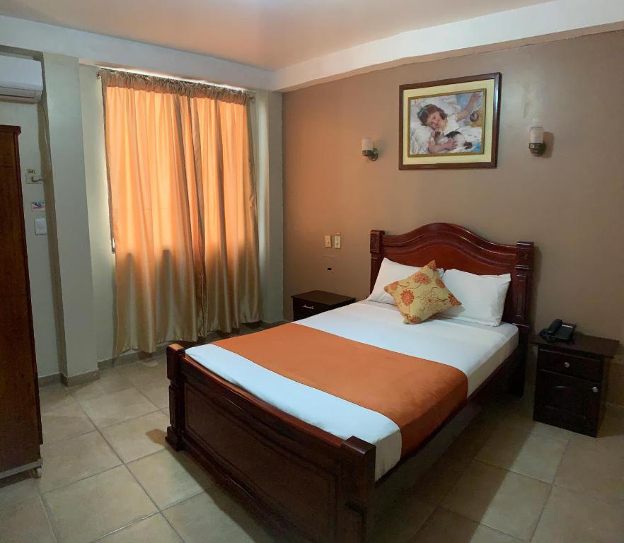 1 dormitorio con cama y ventana en Hotel Deseos en Guayaquil