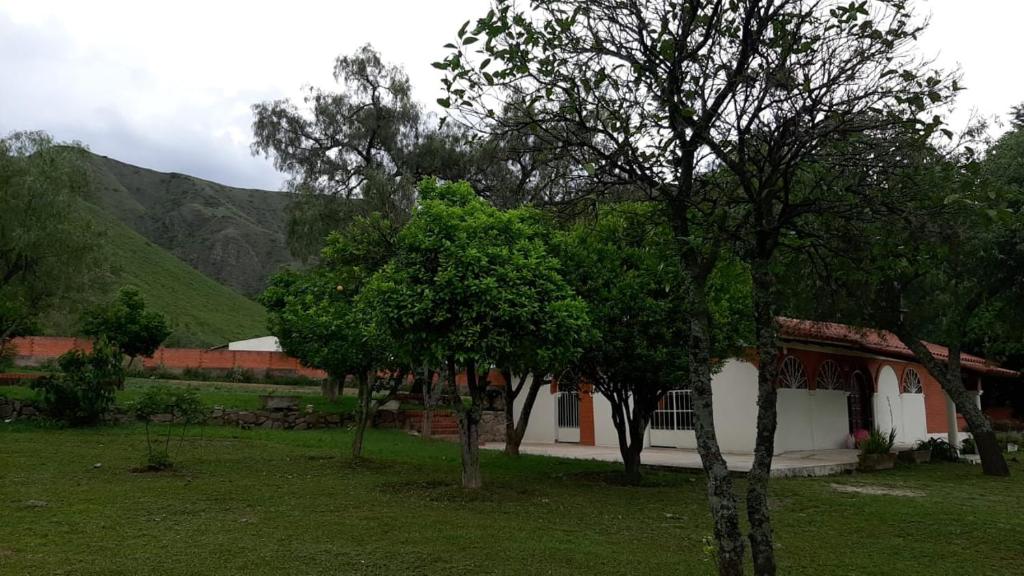 a group of trees in front of a house at Cabañita Villa Bella Tarija in Tarija