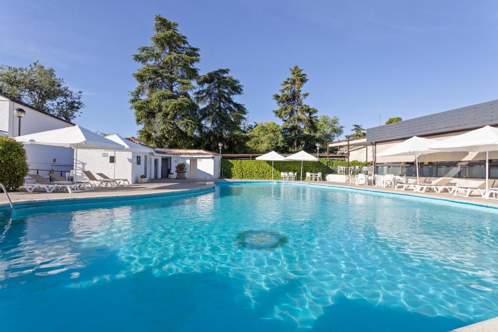 a large swimming pool with blue water at Hotel Best Osuna in Madrid