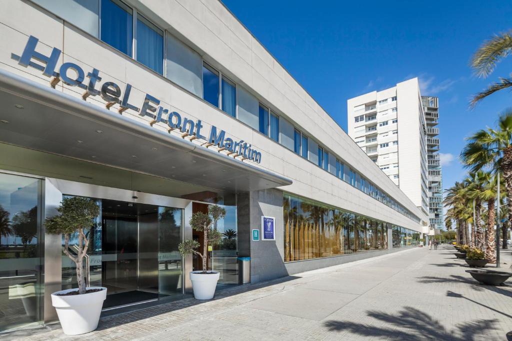 a hospital building with palm trees in front of it at Hotel Best Front Maritim in Barcelona
