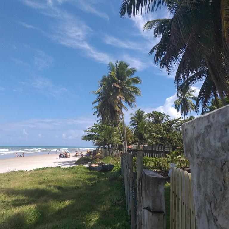 伊列烏斯的住宿－Casa de Praia，享有棕榈树海滩和围栏的景色