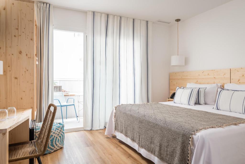 リョレート・デ・マルにあるALEGRIA Mariner Adults Onlyのベッドと机と窓のある寝室