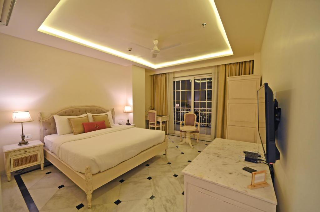 Habitación de hotel con cama y TV en The Castle by KLR, en Udaipur