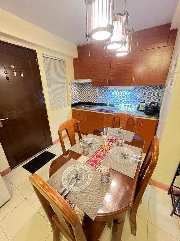 une cuisine avec une table en bois et des chaises ainsi qu'une salle à manger dans l'établissement AZ Suites 2 bedroom Camella Northpoint, à Davao