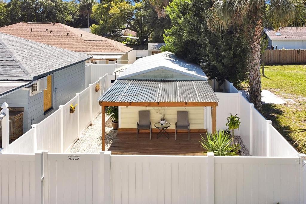 une clôture blanche et une maison blanche avec une terrasse couverte dans l'établissement Comfortable private room in Tampa: Villa Romantic., à Tampa