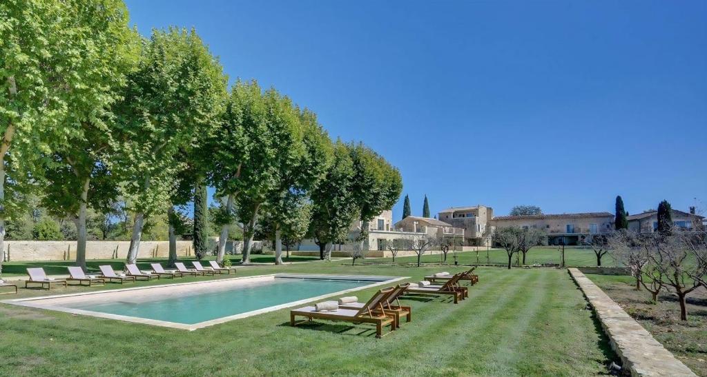 a swimming pool with lounge chairs next to a park at Domaine de Privadière in Garrigues-et-Sainte-Eulalie