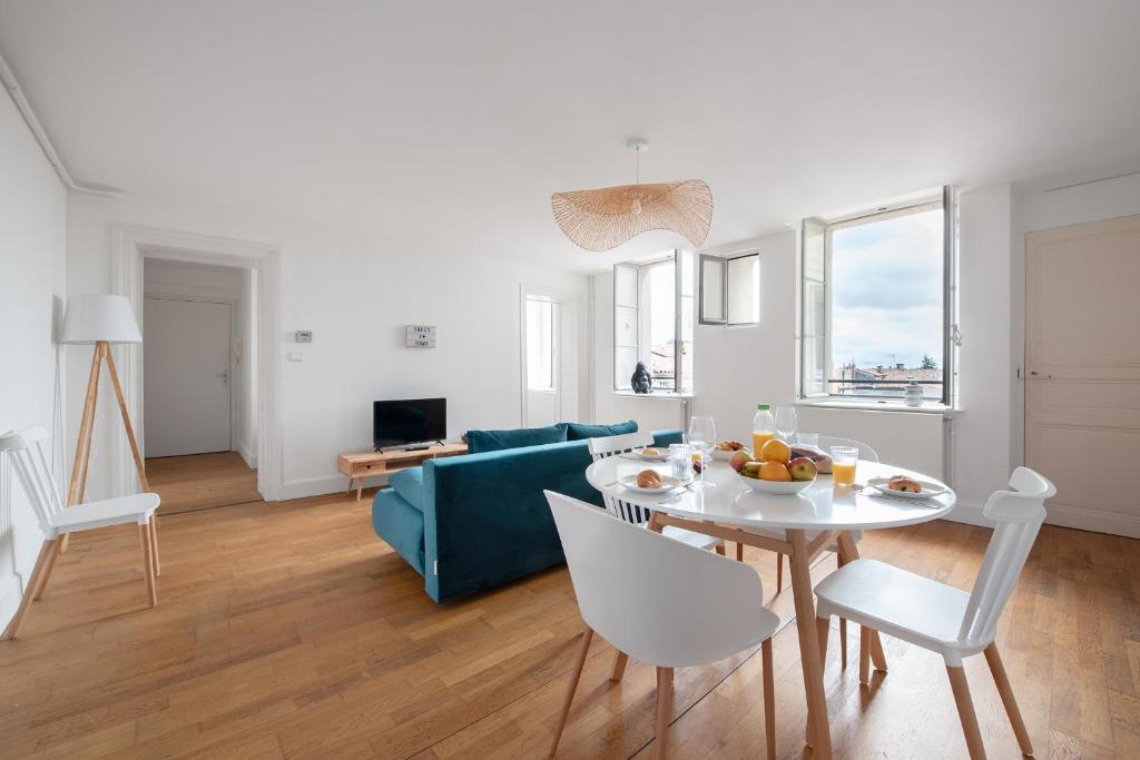 sala de estar con sofá azul y mesa en T3 Duplex - Vue sur toits & Cité en Carcasona