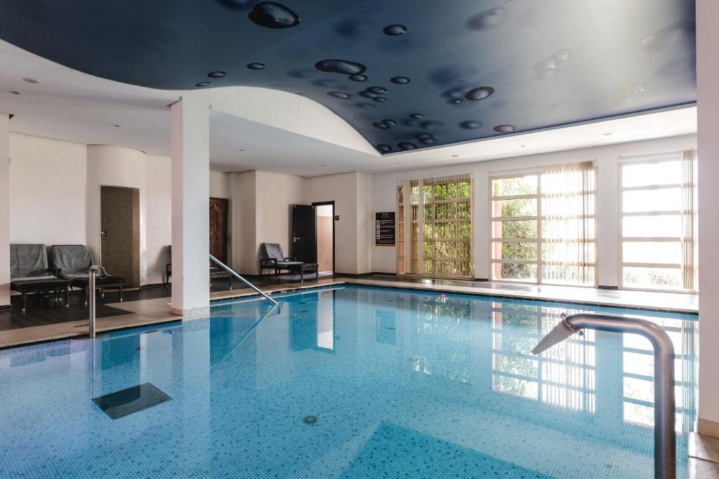 una grande piscina in un edificio con soffitto di Kenzi Menara Palace & Resort a Marrakech