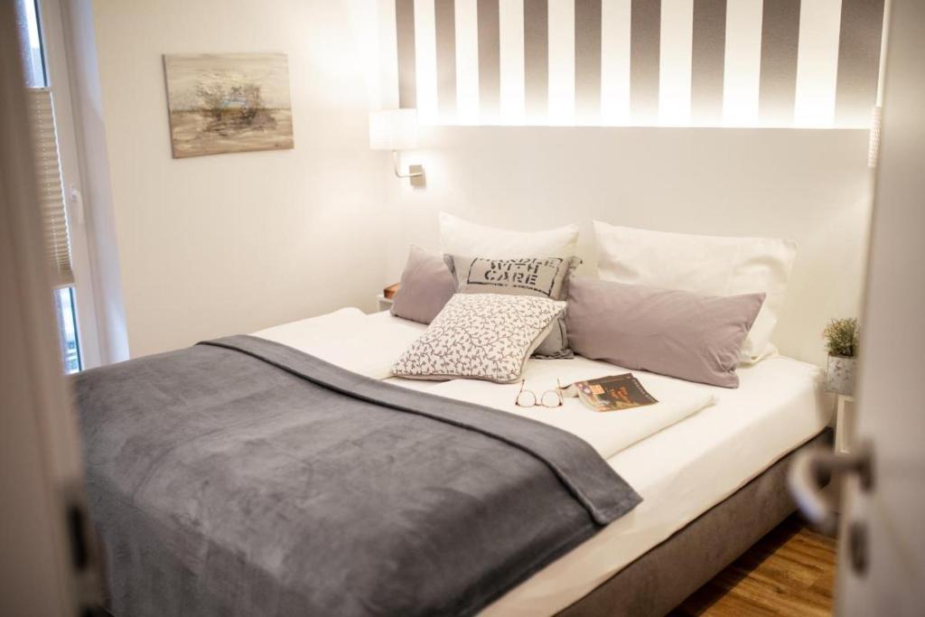 ein Schlafzimmer mit einem weißen Bett mit Kissen in der Unterkunft Rodehuus Wohnung 7 in Borkum