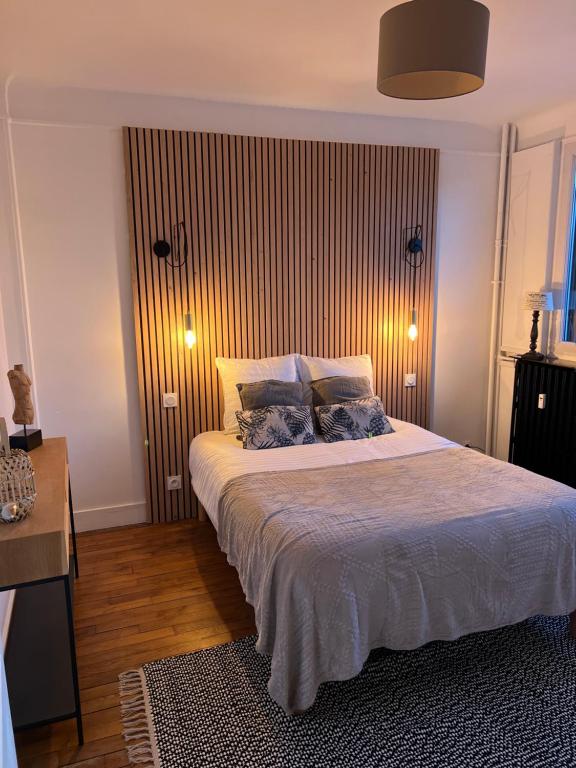 a bedroom with a large bed with two pillows at Le cosy Versaillais in Versailles