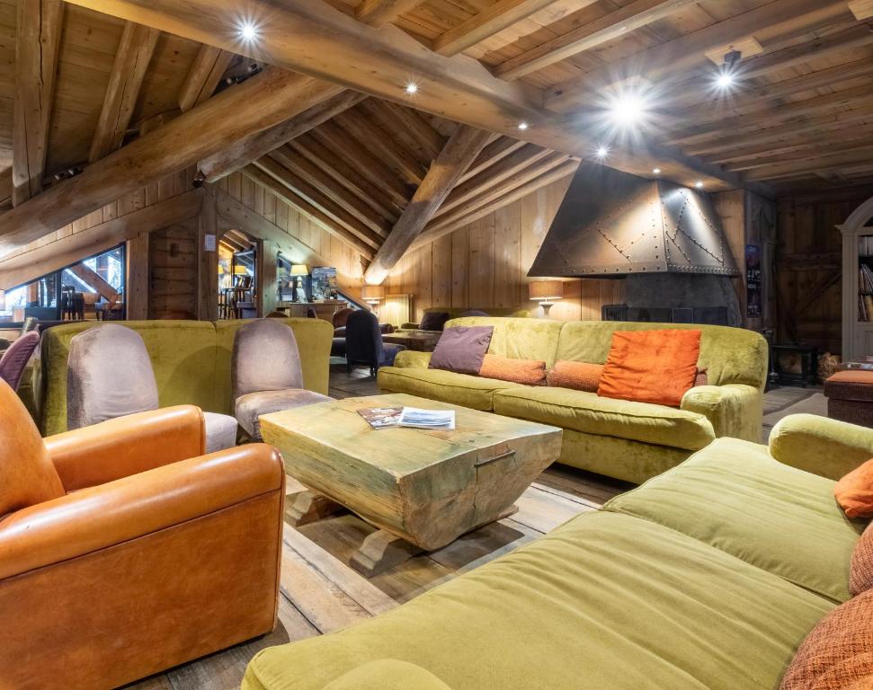a living room with several couches and a table at Résidence Pierre & Vacances Premium Les Fermes De Méribel in Méribel