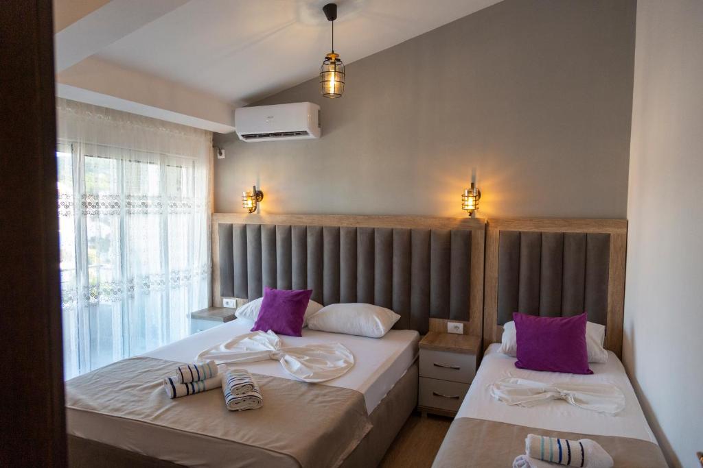 a bedroom with two beds with purple pillows at Kenzy Apartments in Ulcinj