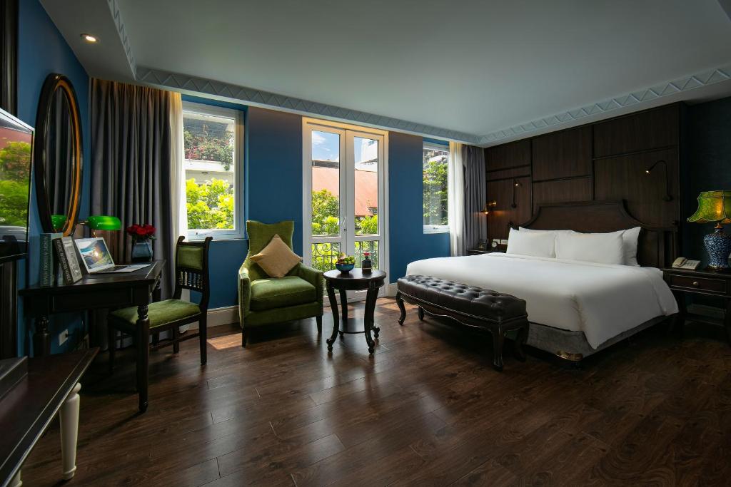 una camera con letto, scrivania e sedia di O'Gallery Premier Hotel & Spa a Hanoi