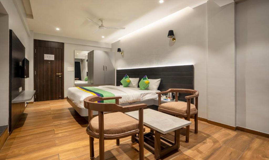 una camera d'albergo con letto, tavolo e sedie di Treebo Trend Prasha a Nashik