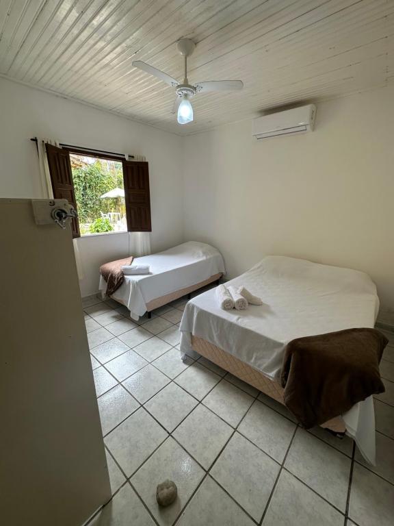 a bedroom with two beds and a window at Pousada 3 Pequis in Arraial d'Ajuda