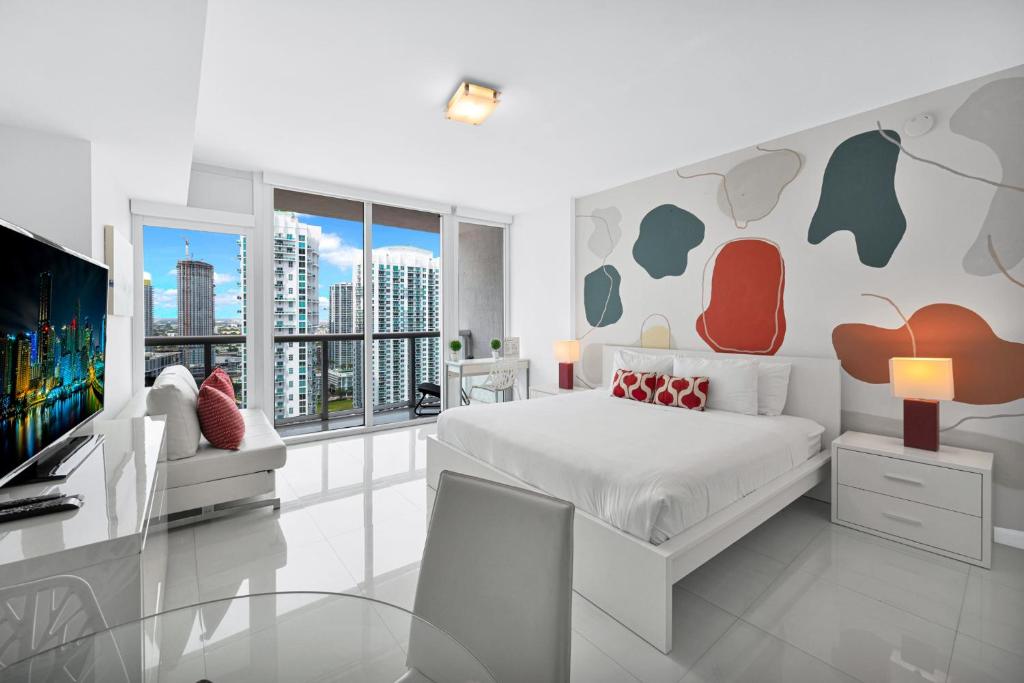 a white bedroom with a bed and a tv at Stylish Studio Icon, W Hotel Waterfront Building in Miami