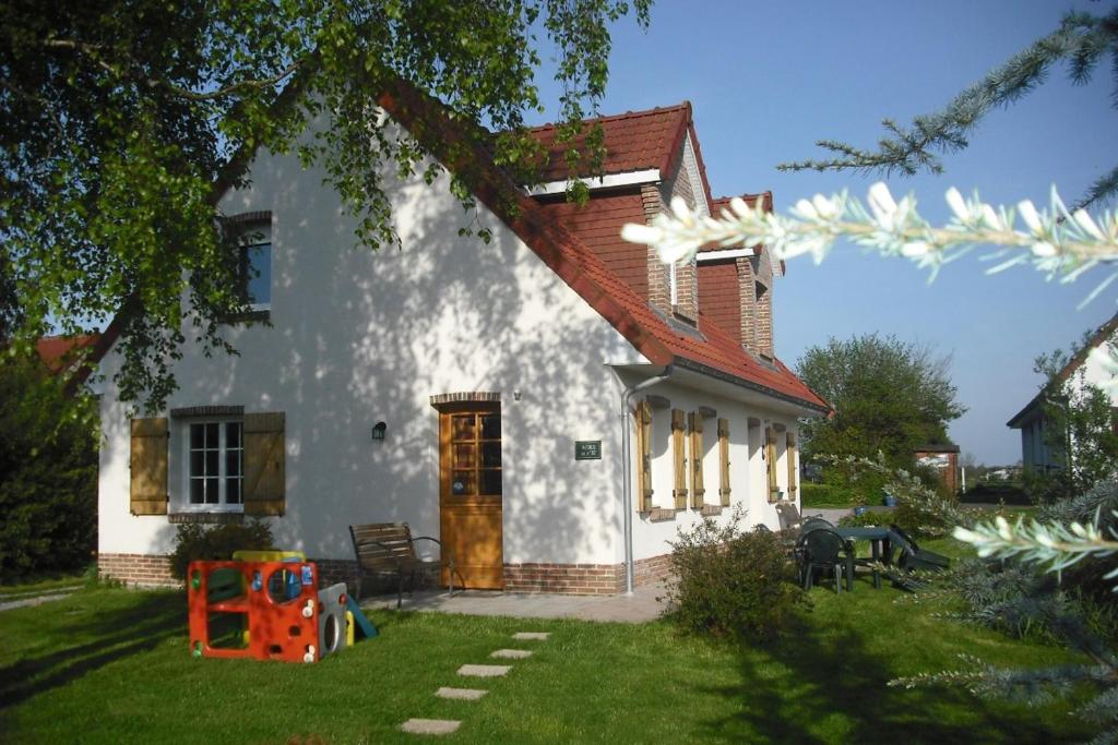 Casa blanca con techo rojo y patio en Gîte 2 pers en Saint-Pol-sur-Ternoise