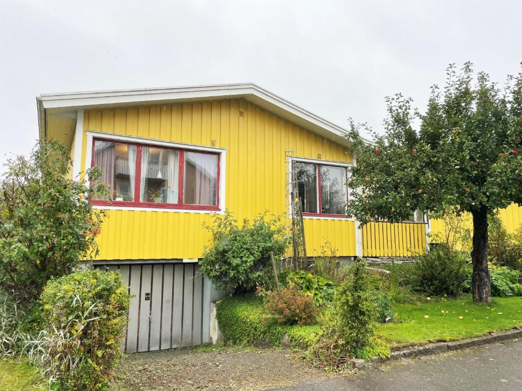 uma casa amarela com uma garagem branca em Well-equipped holiday home in Varnamo em Värnamo