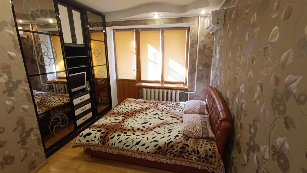 a small bedroom with a bed with a leopard print blanket at Аренда квартиры посуточно in Cherkasy