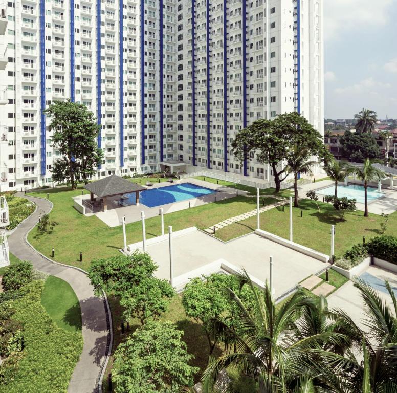 a large apartment building with a park and a swimming pool at Grass residence tower2 29th in Manila