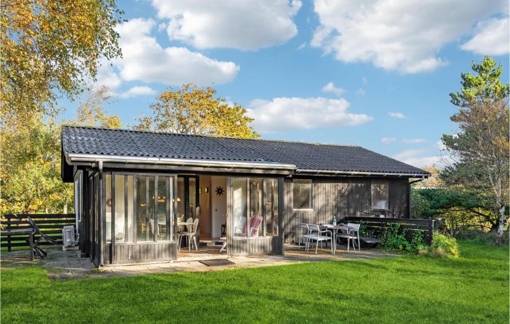 a small shed with a table and chairs in a yard at Pet Friendly Home In Fan With Wifi in Fanø
