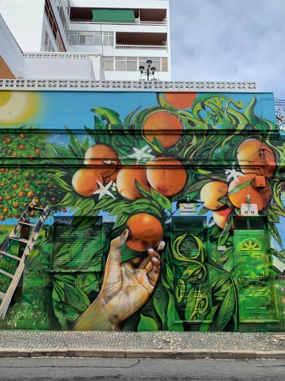 una pared con una pintura de naranjas en ella en Casa Laranjeira Olhão, en Olhão