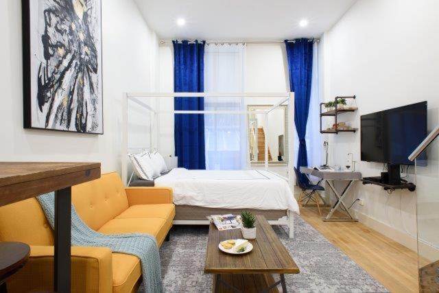 uma sala de estar com um sofá e uma cama em 75-A New stylish Loft 1BR W D Prime Upper east em Nova York