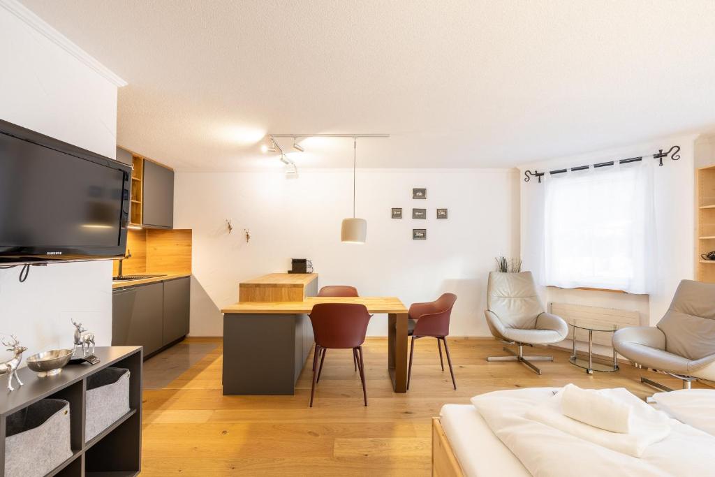 a kitchen and living room with a table and chairs at 7304 Pure Freude in dieser stilvoll renovierten Wohnung mit moderner Kueche in Vulpera