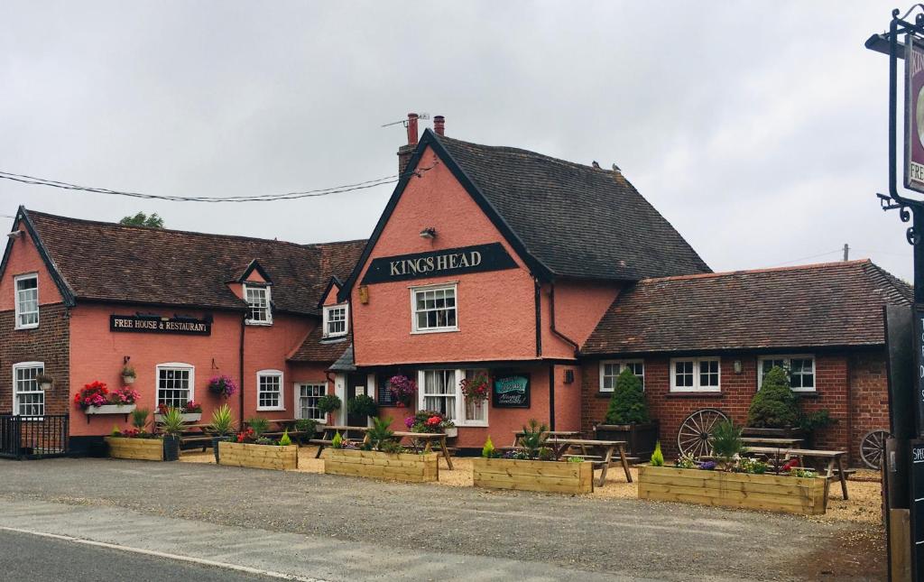 ein Gasthaus mit Tischen und Bänken davor in der Unterkunft Kings head Inn 