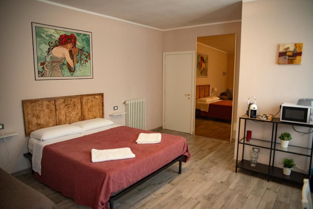 1 dormitorio con 1 cama con 2 toallas en La Corte di Aldo, en Rozzano