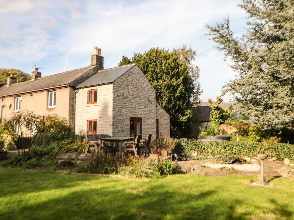 a house with a table and chairs in the yard at Croft Cottage in Castleton