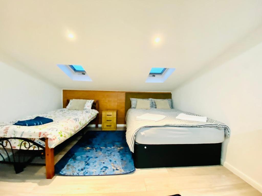a bedroom with two beds and a blue rug at One Bed Studio with Free private Car Park in London in London