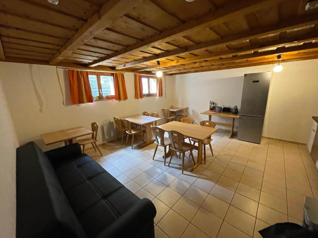un soggiorno con divano e tavoli e una cucina di Pension Balm a Meiringen