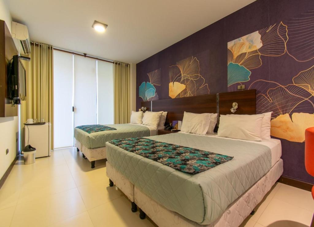 a hotel room with two beds and a tv at Mai Suites Apart Hotel in Santa Cruz de la Sierra