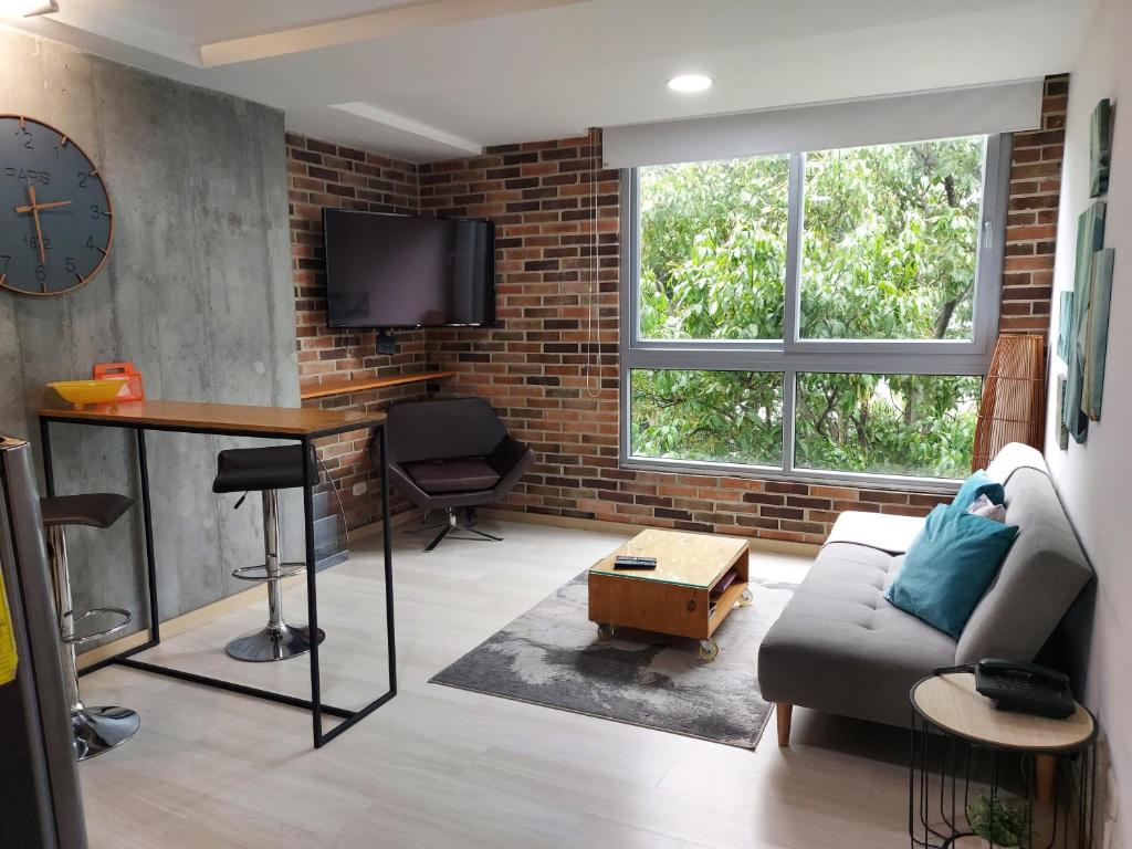 a living room with a couch and a table and a clock at San Peter Family Suites in Medellín