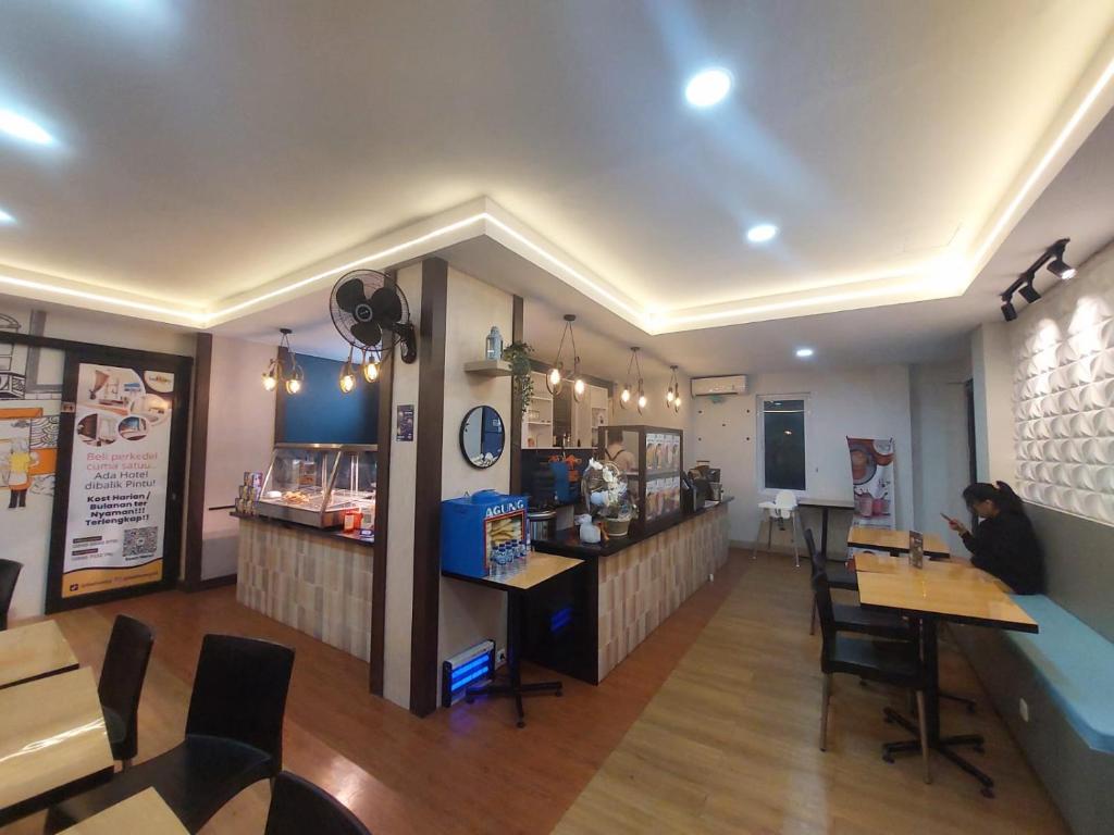 a fast food restaurant with a woman sitting at a table at Behomy Corner Eight Lippo Karawaci in Tangerang