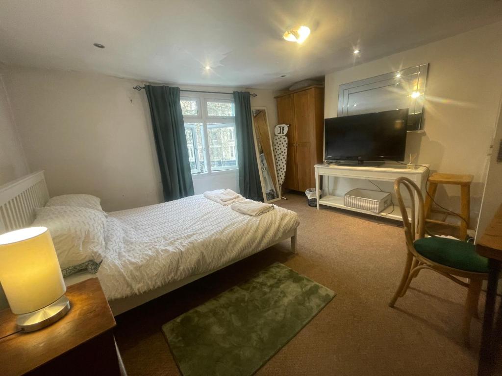 ロンドンにあるPrivate Double Roomのベッドルーム(ベッド1台、薄型テレビ付)