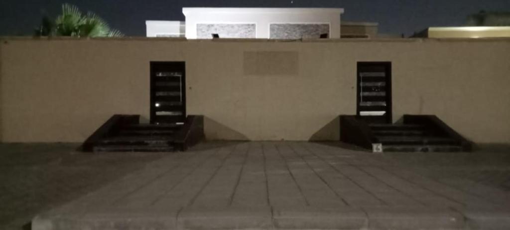 un edificio con tre scalinate e un muro di شالية لايت مون a Dammam