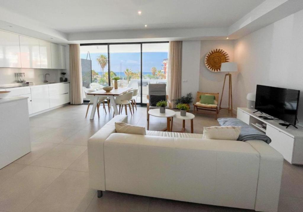 a living room with a white couch and a kitchen at Sealine Vidorra in Torrox Costa