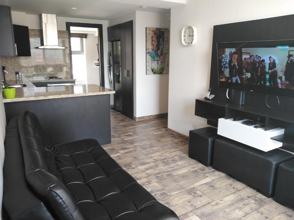 a living room with a couch and a tv at Apartasuites AV in Medellín