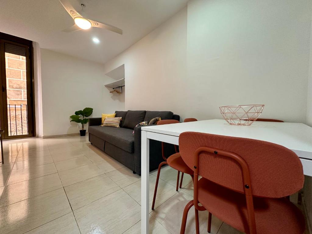 Una sala de estar con un sofá, una mesa y sillas. en Little Horse apartments 1, en Tarragona