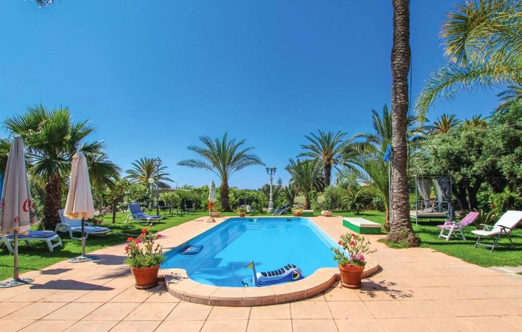 una piscina en un complejo con palmeras en 6 bedrooms villa at Alicante 800 m away from the beach with private pool enclosed garden and wifi, en La Marina