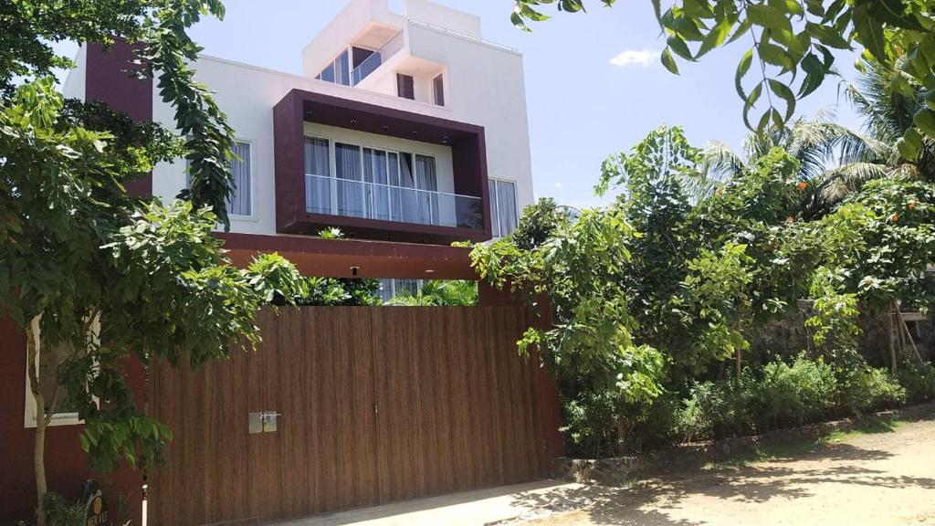 a house with a wooden fence in front of it at Mer Vue Villa, Kovalam, ECR, Chennai in Chennai